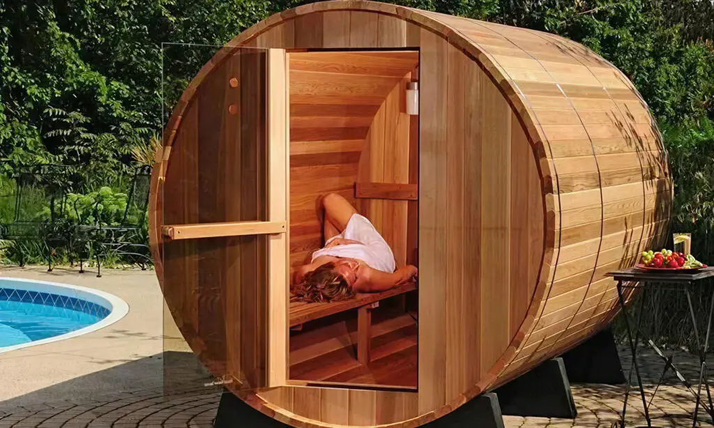 Barrel sauna with lady laying on bench in white towel