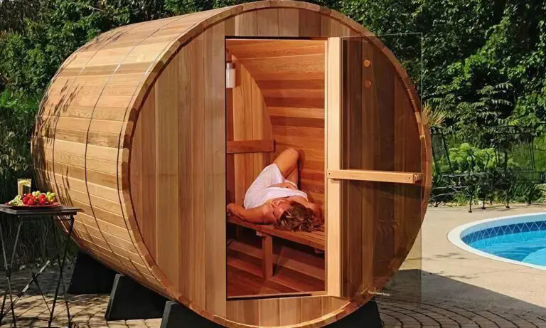 Barrel sauna with lady laying on bench in white towel