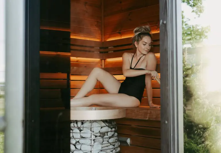 lady pouring water on nest sauna heater