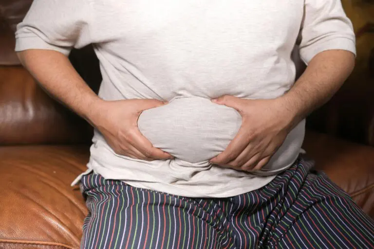 Man holding fat in his belly with his hands